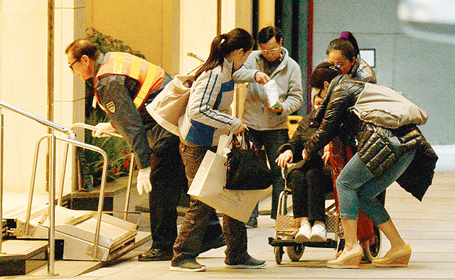 兩個外傭一個推輪椅,一個一袋二袋,離開中建大廈一出到街,葉蒨文即刻用張氈遮住媽咪雙腳,以免佢凍親。